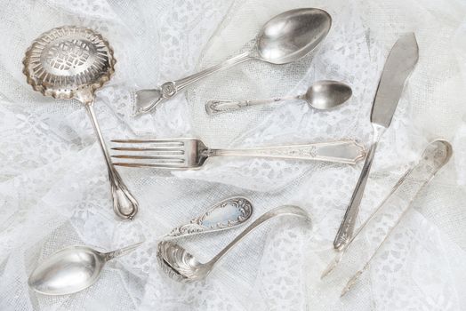 Silverware on a white guipure fabric closeup