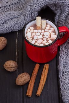 Hot cocoa with marshmallows with spices on the old wooden boards. Coffee, cocoa, cinnamon, nuts, cozy sweater. Autumn Still Life