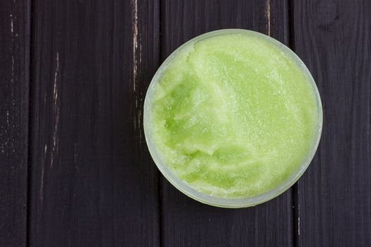 green body scrub on the black wooden background