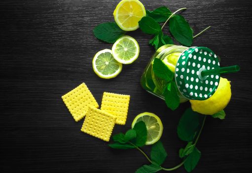 Mint herbal tea in glass cup with lemon on wooden background