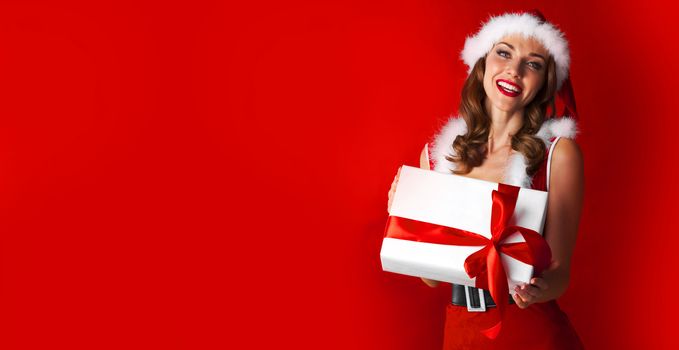 Beautiful woman in Santa Claus style dress with gift box