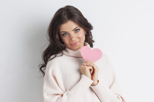 Happy young smiling woman with pink paper heart