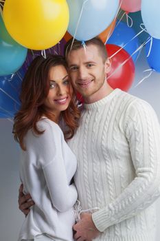 Young smiling hugging couple with balloons