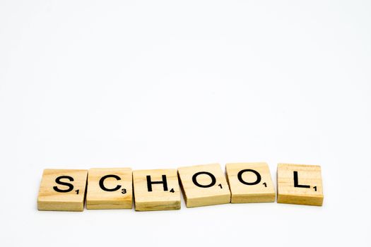 Scrabble tiles with word School written in a white background