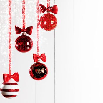 Red Christmas balls hanging on red ribbons on white background