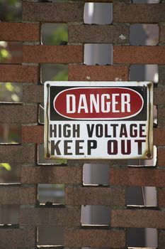 Danger high voltage keep out sign on a red brick wall