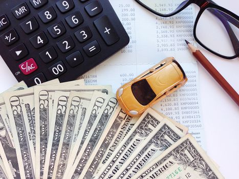 Business, finance, saving money, banking or car loan concept : Miniature car model, calculator and dollar money on office desk table