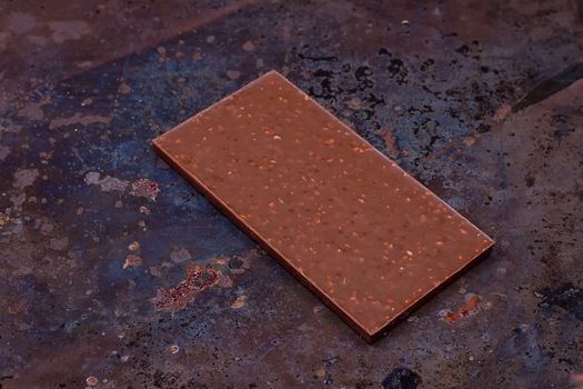 Milk chocolate bar on a black grunge background