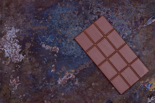 Milk chocolate bar on a black grunge background
