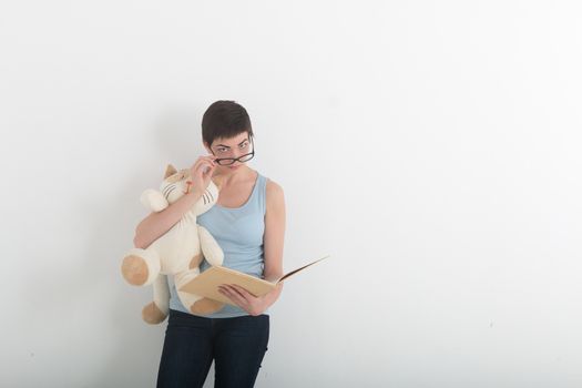 Pretty brunette woman reading book with her plush toy cat
