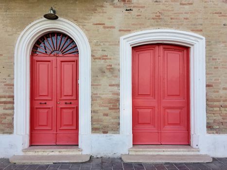 Vintage red doors of a bricked house in Italy