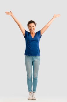 Portrait of a happy middle aged brunette with arms up