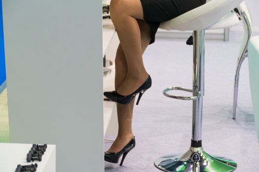 Female feet in short skirt, on stiletto heels, in the office
