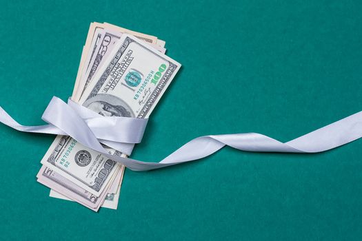 dollars in gift wrapping gift concept. on a green background