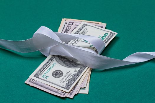 dollars in gift wrapping gift concept. on a green background