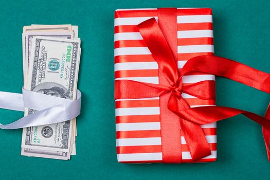 Concept: a gift or money. american money with gift box on a green background