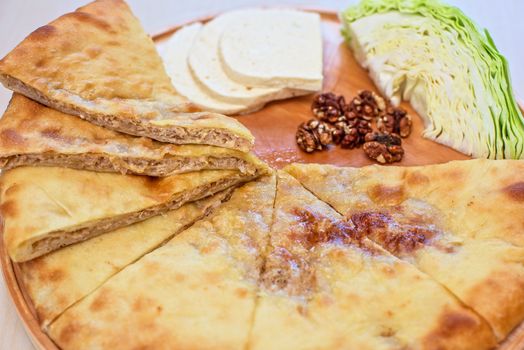 ossetian pie with cabbage and nuts on a white background