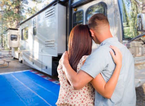 Military Couple Looking At A Beautiful RV At The Campground.