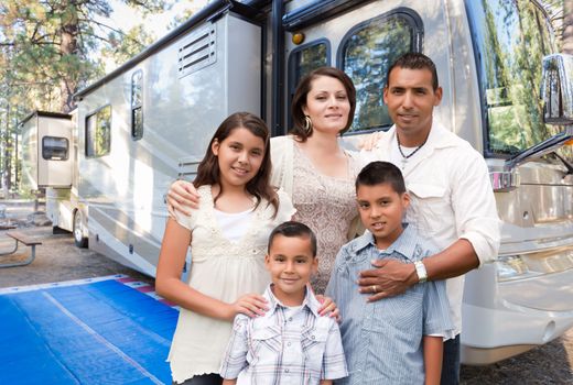 Happy Hispanic Family In Front of Their Beautiful RV At The Campground.