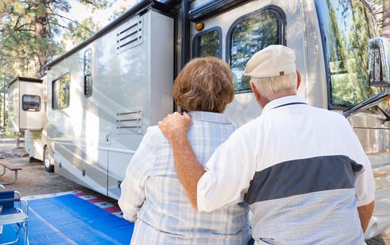 Senior Couple Looking At A Beautiful RV At The Campground.