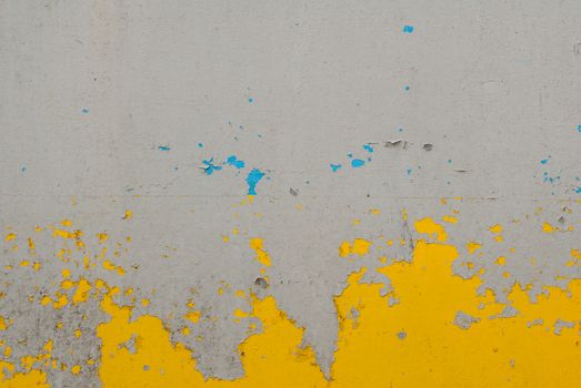 fragment of an iron surface is covered with grey and yellow color paint, which has long been under the influence of different climatic conditions