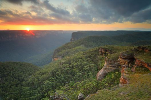 The sun sets in the west over the Grose Valley and  B;ue Mountains from Mt Banks