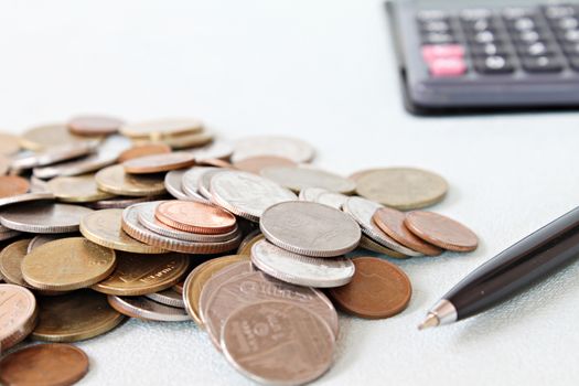 Business, finance, saving money, banking, loan, investment, taxes or accounting concept : Coins, pen and calculator on office desk table