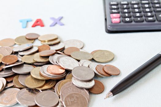 Business, finance, saving money, banking, loan, investment, taxes or accounting concept : Wooden word TAX, coins and calculator on office desk table