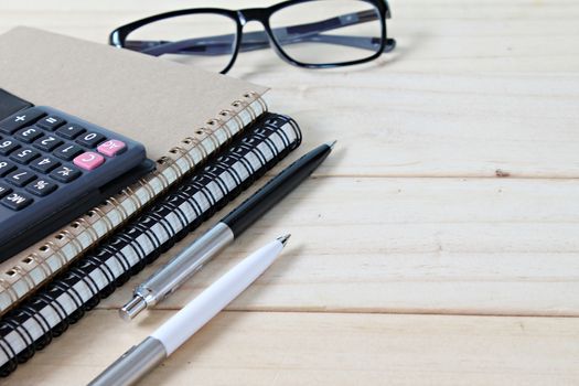 Business, finance, saving money, banking, loan, investment, taxes or accounting concept : Notebooks, calculator and eyeglasses on office desk table