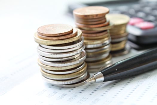 Business, finance, saving money, banking, loan, investment, taxes or accounting concept : Coins stack, pen and calculator on saving account book or financial statement