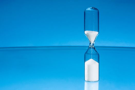 Hourglass with clean blue background