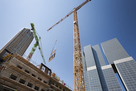 Crane lifting a wall on a construction site in Rotterdam with the Rem Koolhaas building in the background 