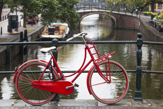 Red bike on a bridge over a canal in Amsterdam