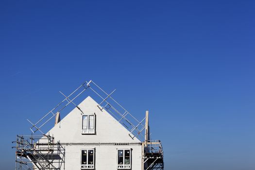 Construction site with houses with prefabricated walls in the Netherlands and a lot of blue sky