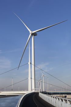 Wind turbines and an asphalted two way bicycle path near canal Hartel in Rotterdam