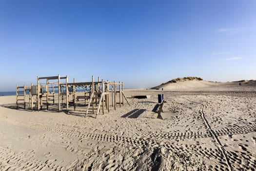 Wooden playground on the beach of Hoek van Holland in the Netherlands with some dunes in the background