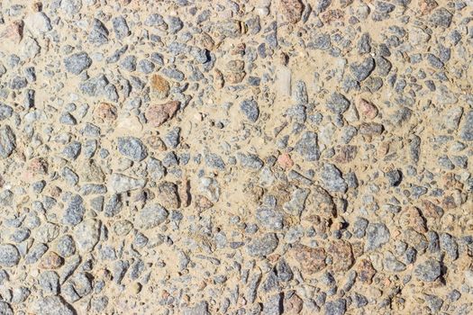 Texture of a fragment of the dirt track with inclusion of pink and gray granite gravel closeup
