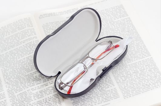 Modern classic men's eyeglasses in case on the open book