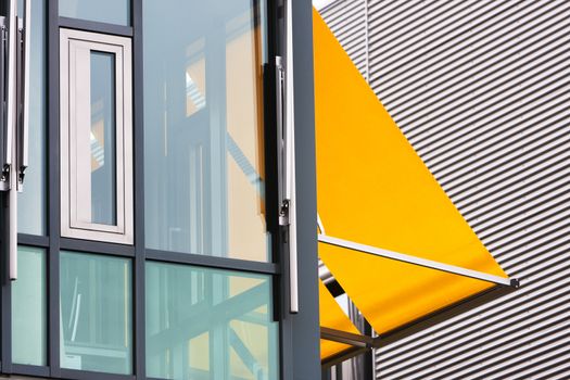 Closeup of a modern office building with yellow awnings 