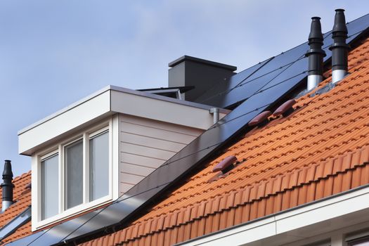 Dormer and solar panels on a red tile roof