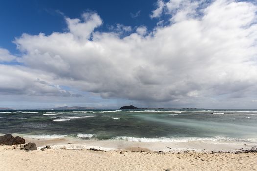 Ocean beach in Corralejo on Fuerteventura with volcano view