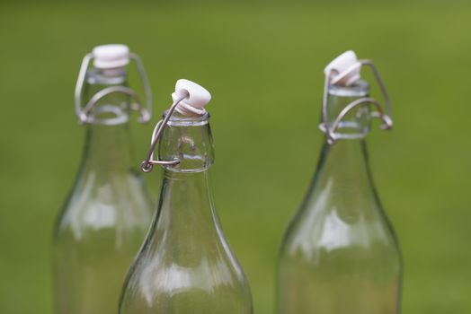 Three old-fashioned authentic Dutch milk bottles against a green natural background
