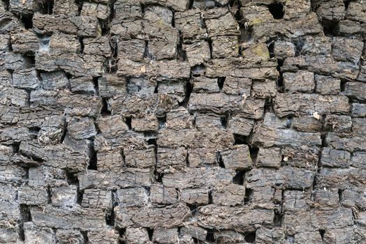 Authentic stacked peat blocks as old-fashioned fossil fuel
