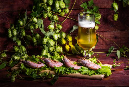 still life with Beer, shrimps and salad on a wooden table