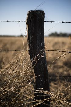 Sharp and rusted timber and metal fence in the countryside of Peak Crossing in Queensland.