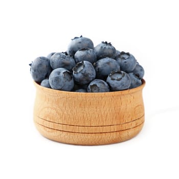 Portion of fresh blueberry berries in rustic wooden bowl isolated on white background, close up, low angle view