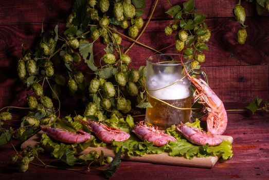 still life with Beer, shrimps and salad on a wooden table