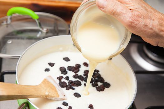 Rice Pudding with cinnamon and raisins preparation : Adding sweetened condensed milk to the cooked rice