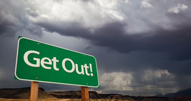 Get Out Green Road Sign with Dramatic Clouds and Rain.