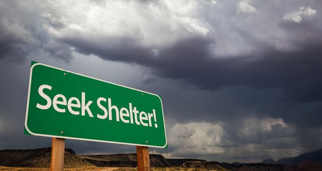 Seek Shelter Green Road Sign with Dramatic Clouds and Rain.